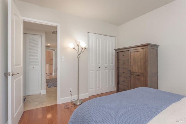 bedroom featuring light wood-style floors, a closet, and baseboards