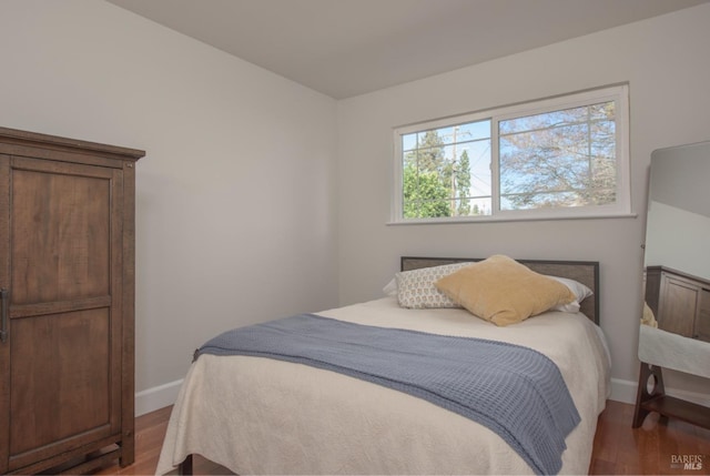 bedroom with baseboards and wood finished floors