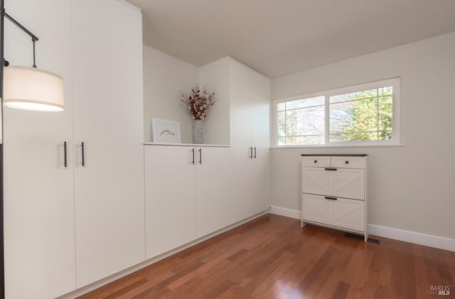 interior space with baseboards and wood finished floors