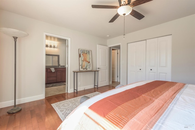 bedroom featuring a closet, baseboards, wood finished floors, and ensuite bathroom