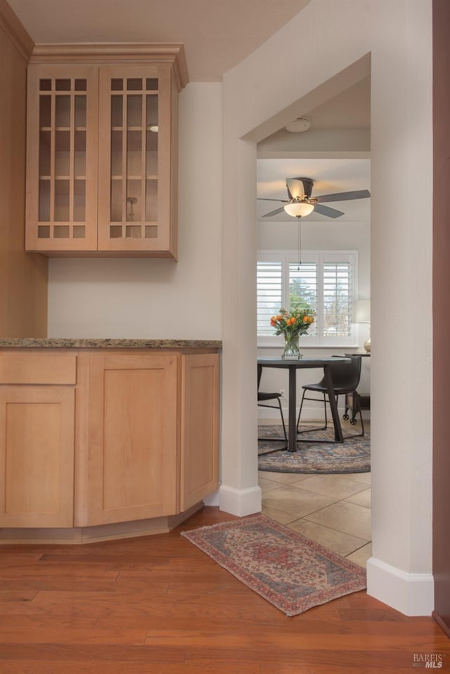 interior space featuring baseboards, light wood-type flooring, and a ceiling fan