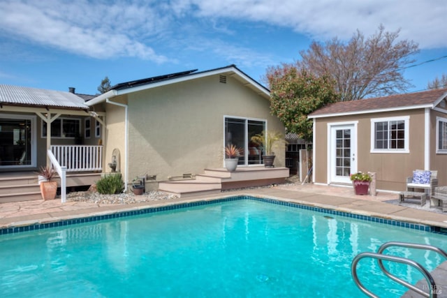 pool featuring an outdoor structure, a storage structure, and a patio area