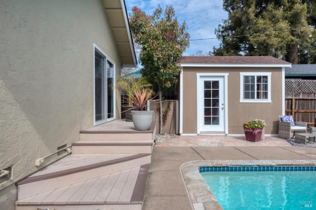 view of pool with a fenced in pool, a patio, an outbuilding, and fence