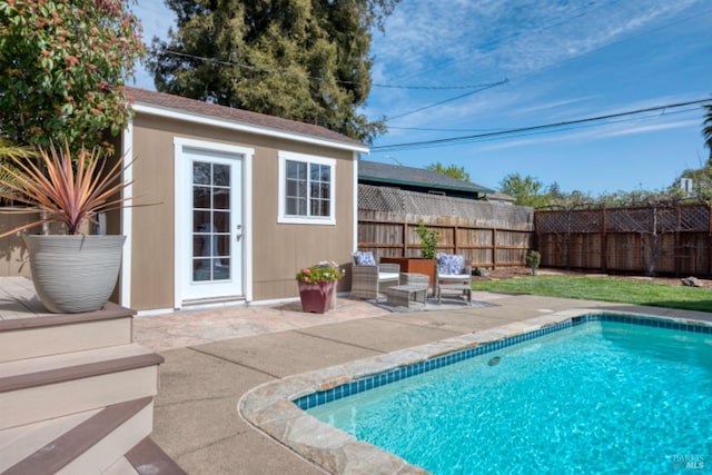 view of swimming pool featuring an outbuilding, a fenced in pool, a patio, and fence