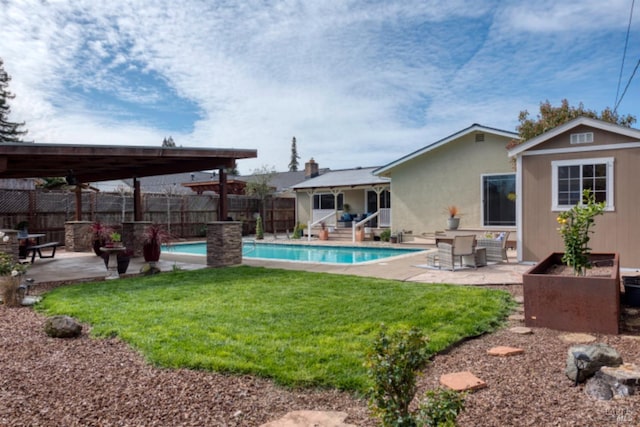 view of pool featuring a patio, fence, a yard, an outdoor structure, and a fenced in pool