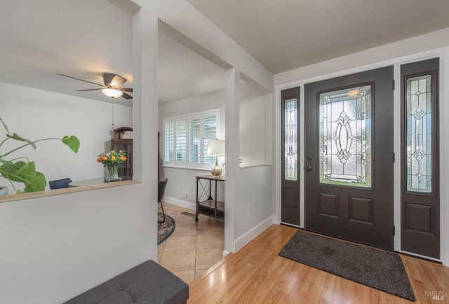 foyer entrance featuring wood finished floors, baseboards, and ceiling fan