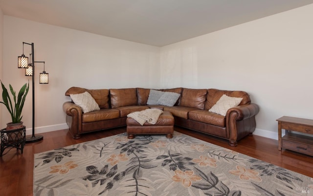 living area with baseboards and wood finished floors