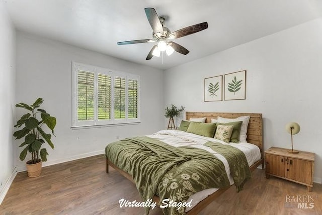 bedroom featuring a ceiling fan, baseboards, and wood finished floors