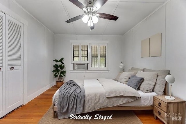 bedroom featuring cooling unit, a ceiling fan, light wood-style flooring, and crown molding