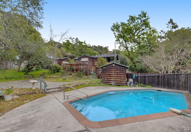 view of pool featuring a storage unit, a patio, an outdoor structure, and a fenced backyard