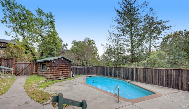 view of pool featuring a patio area, a fenced backyard, a fenced in pool, and an outdoor structure