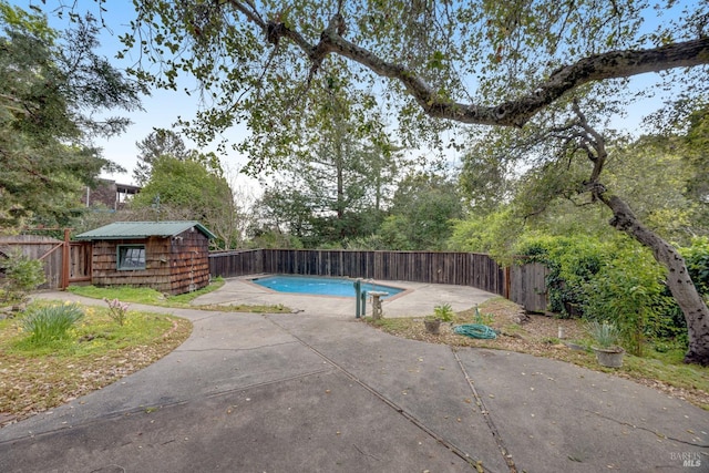 view of pool featuring an outbuilding, a patio, a fenced backyard, a storage shed, and a fenced in pool