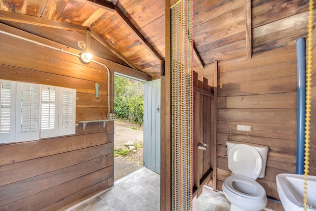 bathroom featuring wood walls, wooden ceiling, toilet, and lofted ceiling with beams