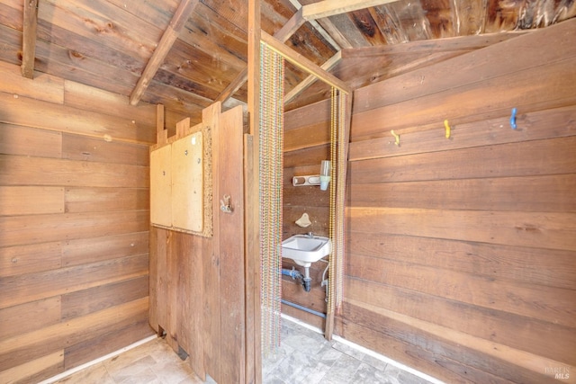 interior details with wood walls, wood ceiling, and a sink