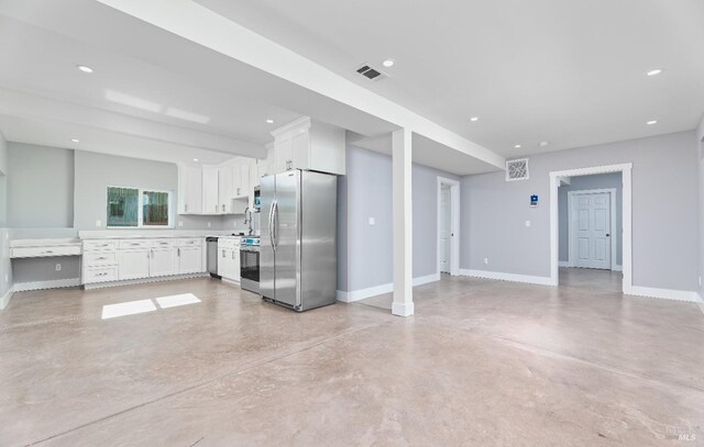 kitchen with white cabinetry, baseboards, concrete flooring, and stainless steel appliances