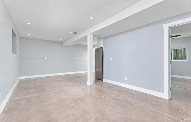 finished below grade area featuring visible vents, recessed lighting, freestanding refrigerator, and baseboards