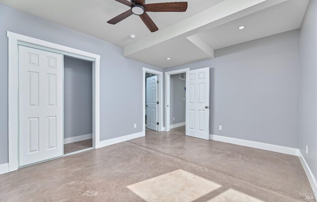 unfurnished bedroom with a closet, a ceiling fan, baseboards, and concrete flooring