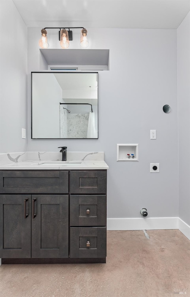 bathroom with vanity, baseboards, and concrete floors