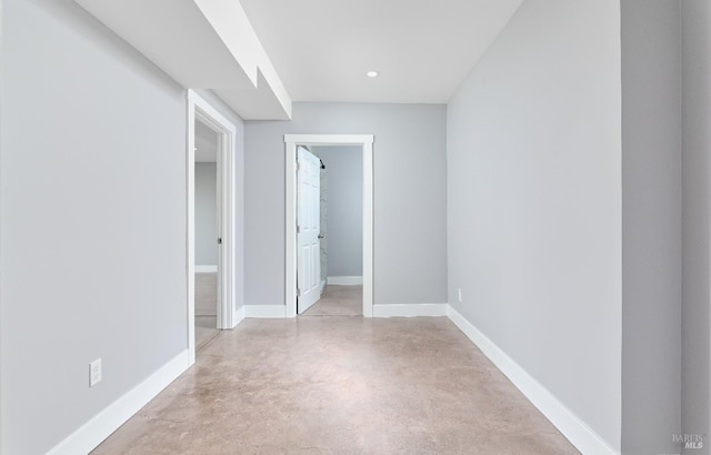 unfurnished room featuring recessed lighting, baseboards, and concrete flooring
