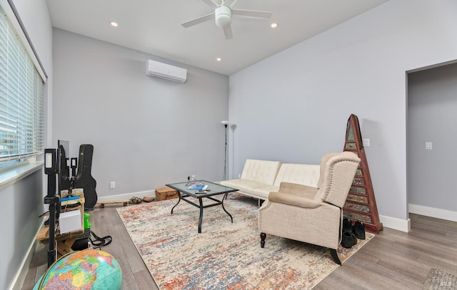 living room featuring a wall mounted air conditioner, a ceiling fan, wood finished floors, recessed lighting, and baseboards