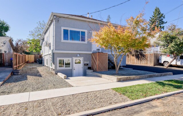 view of home's exterior with an outbuilding, fence, stucco siding, entry steps, and a garage