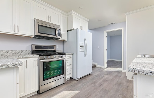 kitchen with baseboards, visible vents, stainless steel appliances, white cabinets, and light wood-type flooring