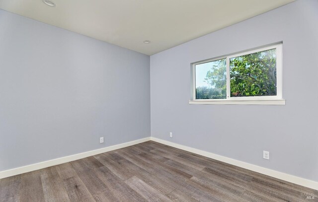 empty room featuring baseboards and wood finished floors