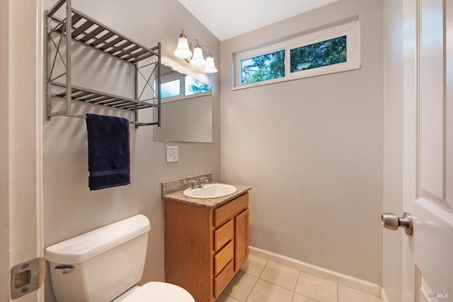 half bathroom with tile patterned flooring, toilet, vanity, and baseboards