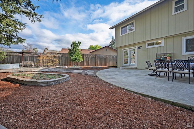 view of yard with a patio, fence, and french doors