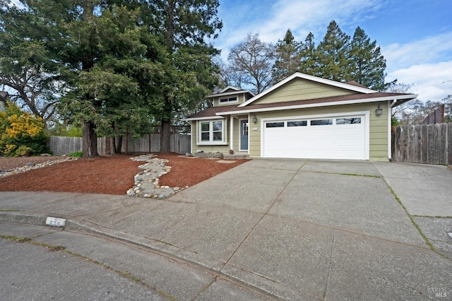 view of front of house featuring an attached garage, a shingled roof, driveway, and fence