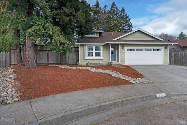 view of front of house with a garage, roof with shingles, driveway, and fence