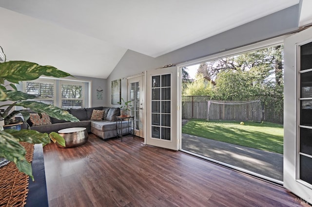 unfurnished living room featuring a wealth of natural light, lofted ceiling, and wood finished floors