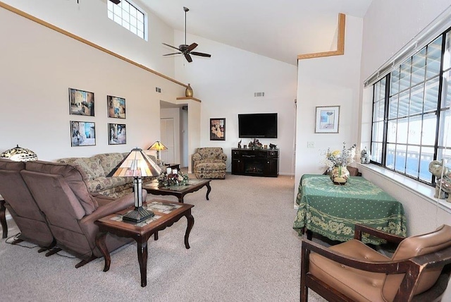 living area with a ceiling fan, a high ceiling, carpet, and visible vents