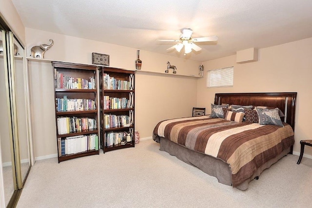 carpeted bedroom with a ceiling fan, baseboards, and a textured ceiling