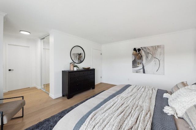 bedroom with crown molding, wood finished floors, and baseboards