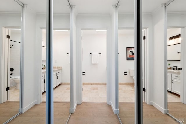 corridor with crown molding and light wood-type flooring