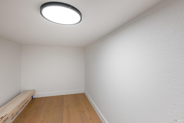 spare room featuring light wood-type flooring and baseboards