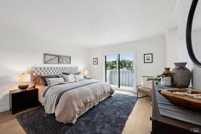 bedroom featuring access to exterior, baseboards, light wood-style floors, and ornamental molding