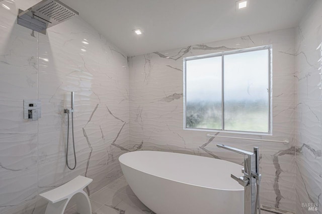 full bath featuring a marble finish shower, a freestanding tub, marble finish floor, and tile walls