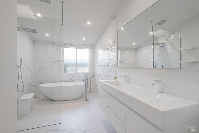 bathroom with vanity, visible vents, a freestanding tub, tile walls, and marble finish floor