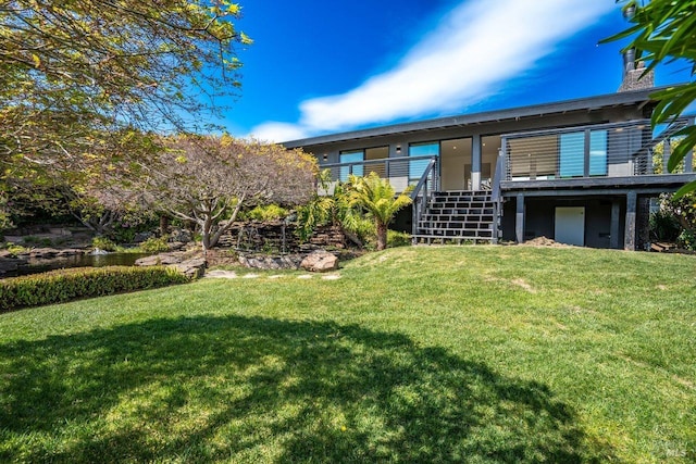 back of property with stairway and a lawn