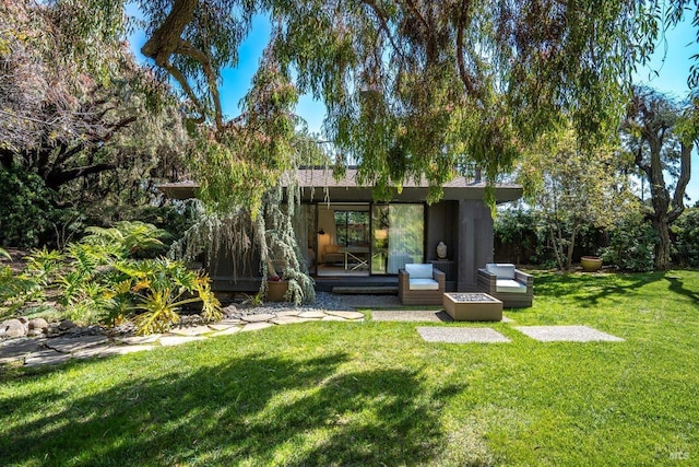 rear view of house with a lawn and stucco siding