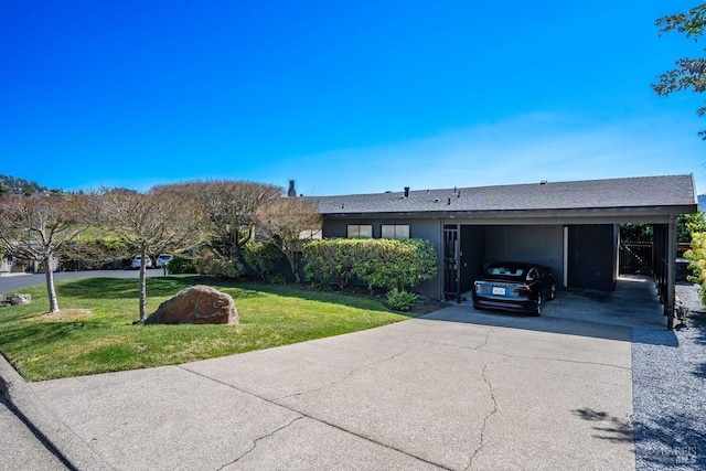 view of front of property featuring an attached carport, concrete driveway, a front lawn, and roof with shingles