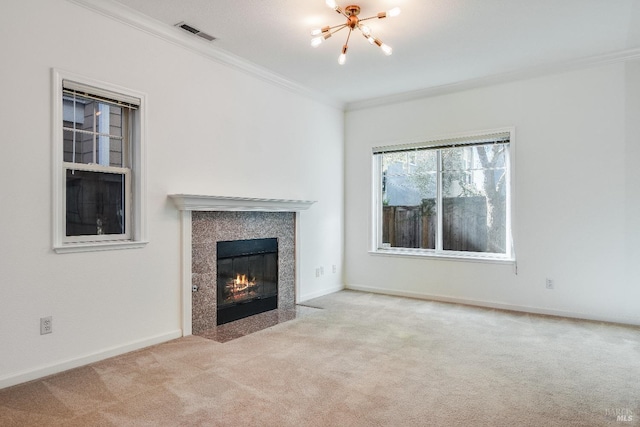 unfurnished living room featuring carpet flooring, a tiled fireplace, a notable chandelier, visible vents, and ornamental molding