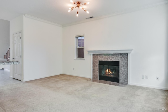 unfurnished living room with ornamental molding, carpet flooring, baseboards, visible vents, and a notable chandelier