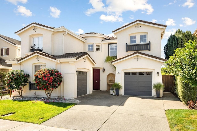 mediterranean / spanish-style home with fence, a tiled roof, concrete driveway, stucco siding, and an attached garage