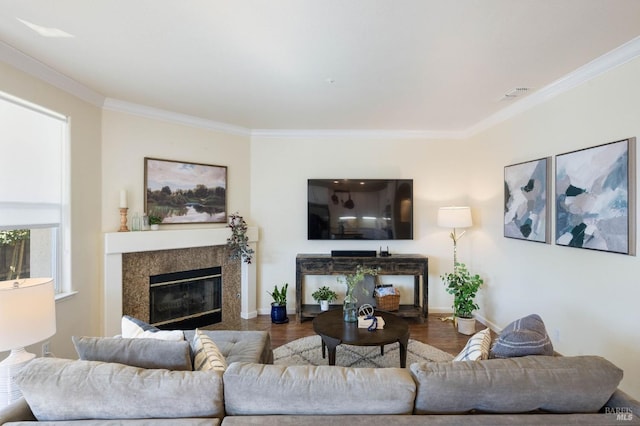 living area with wood finished floors, crown molding, a fireplace, and visible vents