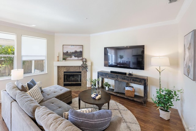 living room featuring a tile fireplace, wood finished floors, baseboards, and ornamental molding