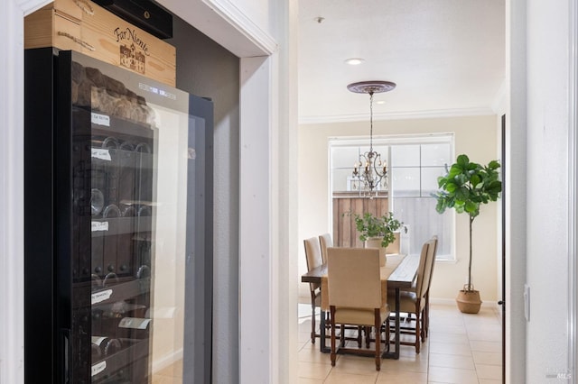 dining area featuring light tile patterned floors, baseboards, an inviting chandelier, and crown molding