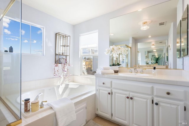 bathroom featuring visible vents, walk in shower, a bath, and vanity